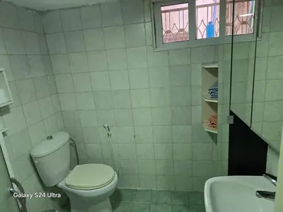 a bathroom with a white toilet and a sink at Lukanda Apartment Feel at Home in Amman