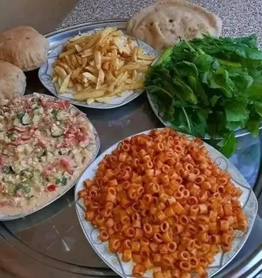 four plates of food on a table with different foods at carfort House in Al Jafr