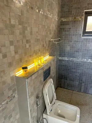a bathroom with a toilet in a tiled room at the royal occasion amman in Amman