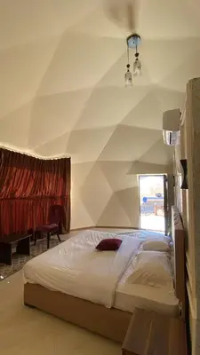 a bedroom with a large bed with a geometric wall at Amin Camp in Wadi Rum