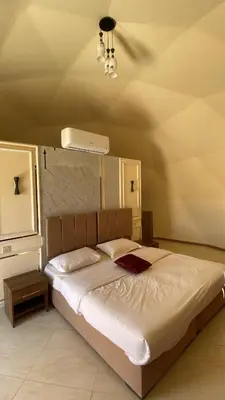 a bedroom with a large bed with a ceiling at Amin Camp in Wadi Rum