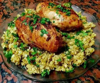a plate of food with chicken and rice on a table at jarmy house in Ash Shajarah