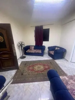 a living room with blue couches and a rug at jarmy house in Ash Shajarah