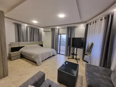a bedroom with a bed and a tv and a couch at Sama Dier Ghbar 5 in Amman