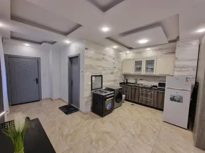 a large kitchen with white appliances and a refrigerator at Sama Dier Ghbar 5 in Amman