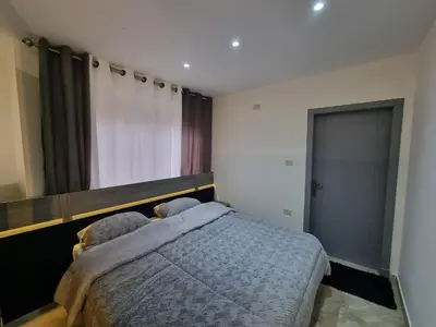 a bedroom with a bed and a large window at Sama Dier Ghbar 6 in Amman