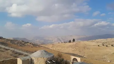a view of a desert with mountains in the distance at Dana local Life Eco lodge in At-Tafilah