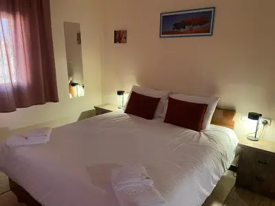 a bedroom with a large white bed with red pillows at Baytna Hotel in Petra
