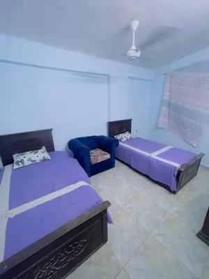 a living room with two beds and a couch at المنشيه ان in Al Manshīyah