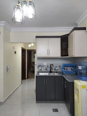 a kitchen with black and white cabinets and appliances at New zarqa20 km from Amman in Az Zarqa