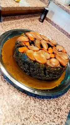 a cake sitting on a plate on a table at دبه حانوت هاوس in Raʼs an Naqb