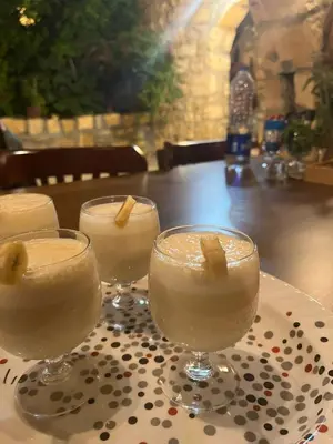 three wine glasses sitting on a table at Hartna zaman in Taiyiba