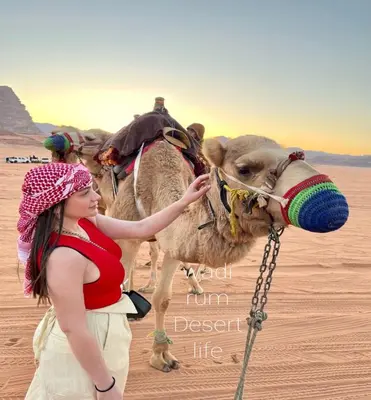 a young girl standing next to a camel in the desert at Aethera Sky Retreat Wadi Rum in Wadi Rum