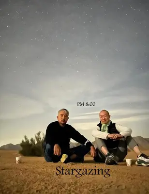 two men sitting in the sand under the stars at Aethera Sky Retreat Wadi Rum in Wadi Rum