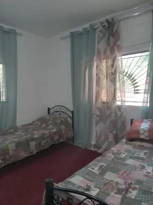 a hotel room with two beds and a window at Leith Holiday Home in ‘Ayn Jannā