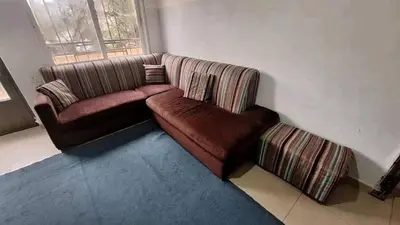 a brown couch in a room with a window at rafat house in Amman