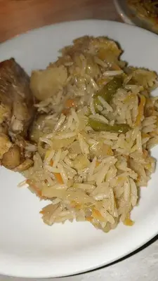 a white plate of food with rice and vegetables at rafat house in Amman