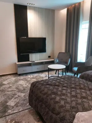a hotel room with a tv and a bed and a table at رياحين الخلود للشقق الفندقية in Amman