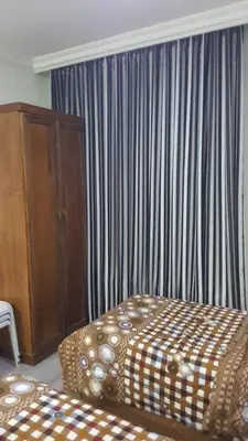 a bedroom with a bed and a dresser and a window at رياحين الخلود للشقق الفندقية in Amman