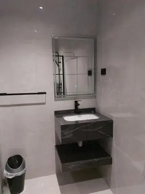 a bathroom with a sink and a mirror at رياحين الخلود للشقق الفندقية in Amman