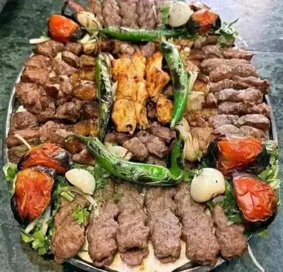 a plate of food with various meats and vegetables at too house in Al Mughayyir