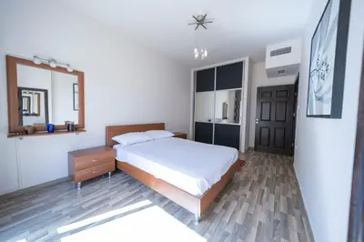 a bedroom with a large bed and a mirror at Tower Apartment in Amman
