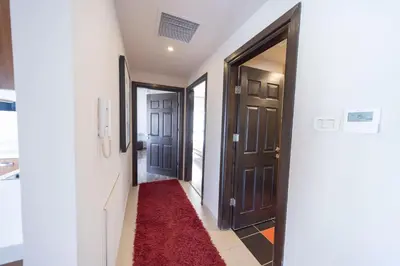 a hallway with two doors and a red carpet at Tower Apartment in Amman