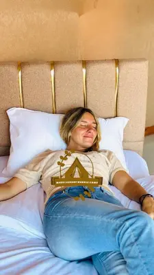 a woman laying on a bed with her head at RUM MARS BUBBLE lUXURY CAMP in Wadi Rum
