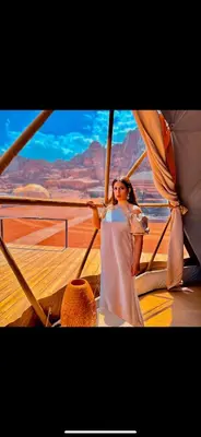 a woman in a white dress standing on a boat at RUM SUNSET BUBBLES lUXURY CAMP in Wadi Rum