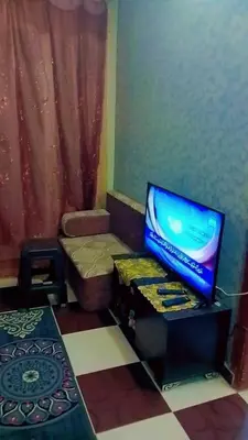 a living room with a tv sitting on a table at الخريطه هاوس in Tall al Misţāḩ