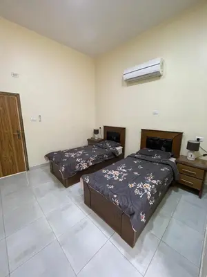 a bedroom with two beds and a air conditioner at Petra 555 Rooms & Apartment in Wadi Musa