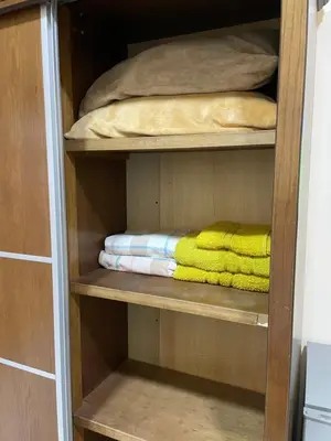 a wooden closet with some towels and a bed at Petra 555 Rooms & Apartment in Wadi Musa