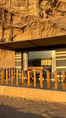 a wooden bench in front of a building at Zahara rum camp & Boutique Resort in Disah
