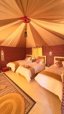 a bedroom with three beds in a tent at Zahara rum camp & Boutique Resort in Disah