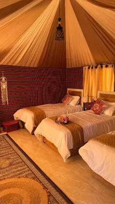 a bedroom with three beds in a tent at Zahara rum camp & Boutique Resort in Disah