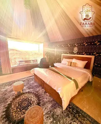 a bedroom with a large bed and a window at Zahara rum camp & Boutique Resort in Disah