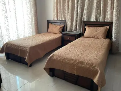 two beds sitting next to each other in a bedroom at الشاعر للشقق المفروشة in Amman