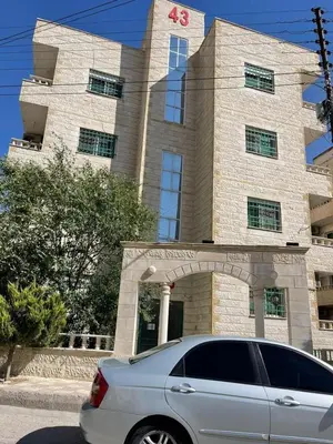 a white car parked in front of a building at الشاعر للشقق المفروشة in Amman