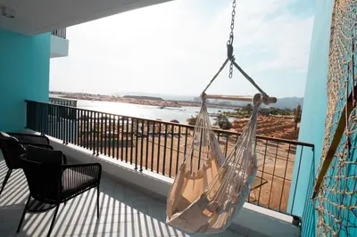 a hammock hanging from a balcony with a view at Ayla B12 Beach Apartment Aqaba in Aqaba