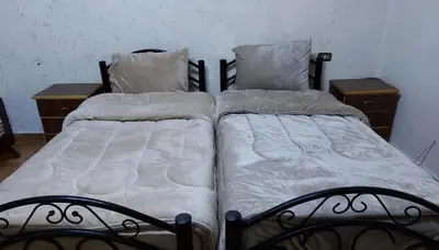 two beds sitting next to each other in a bedroom at بيت الحجر in Amman