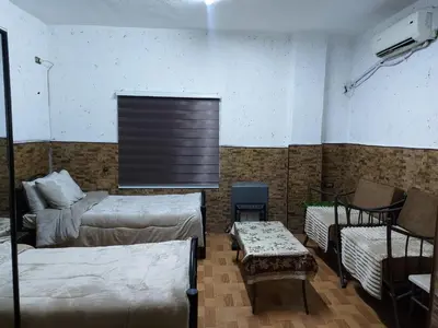 a room with two beds and a couch and a table at بيت الحجر in Amman