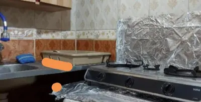 a kitchen with a stove with plastic wrap on it at بيت الحجر in Amman