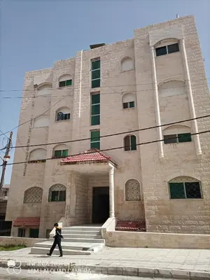 a man walking in front of a building at Decapolis 8 in Irbid