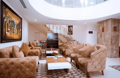 a living room with couches and a staircase at Rawa Luxury Hotel Suites in Amman