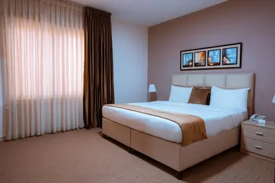 a bedroom with a large bed and a window at Rawa Luxury Hotel Suites in Amman