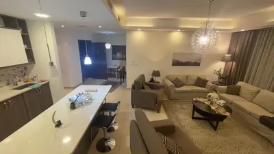 a large living room with a couch and a kitchen at Luxury home Abdoun complex in Amman