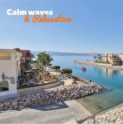 a view of a beach with buildings and the water at Talabay two bedroom umniah pool in Aqaba