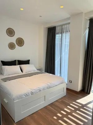 a bedroom with a white bed and a window at DAMAC Pool View Penthouse in Amman
