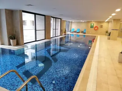 a pool in a hotel room with a blue floor at DAMAC Pool View Penthouse in Amman