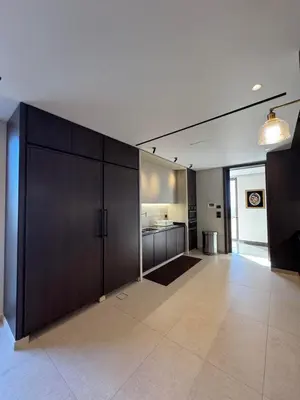 a living room with a large dark wood cabinet at Dabouq Luxurious Penthouse in Amman